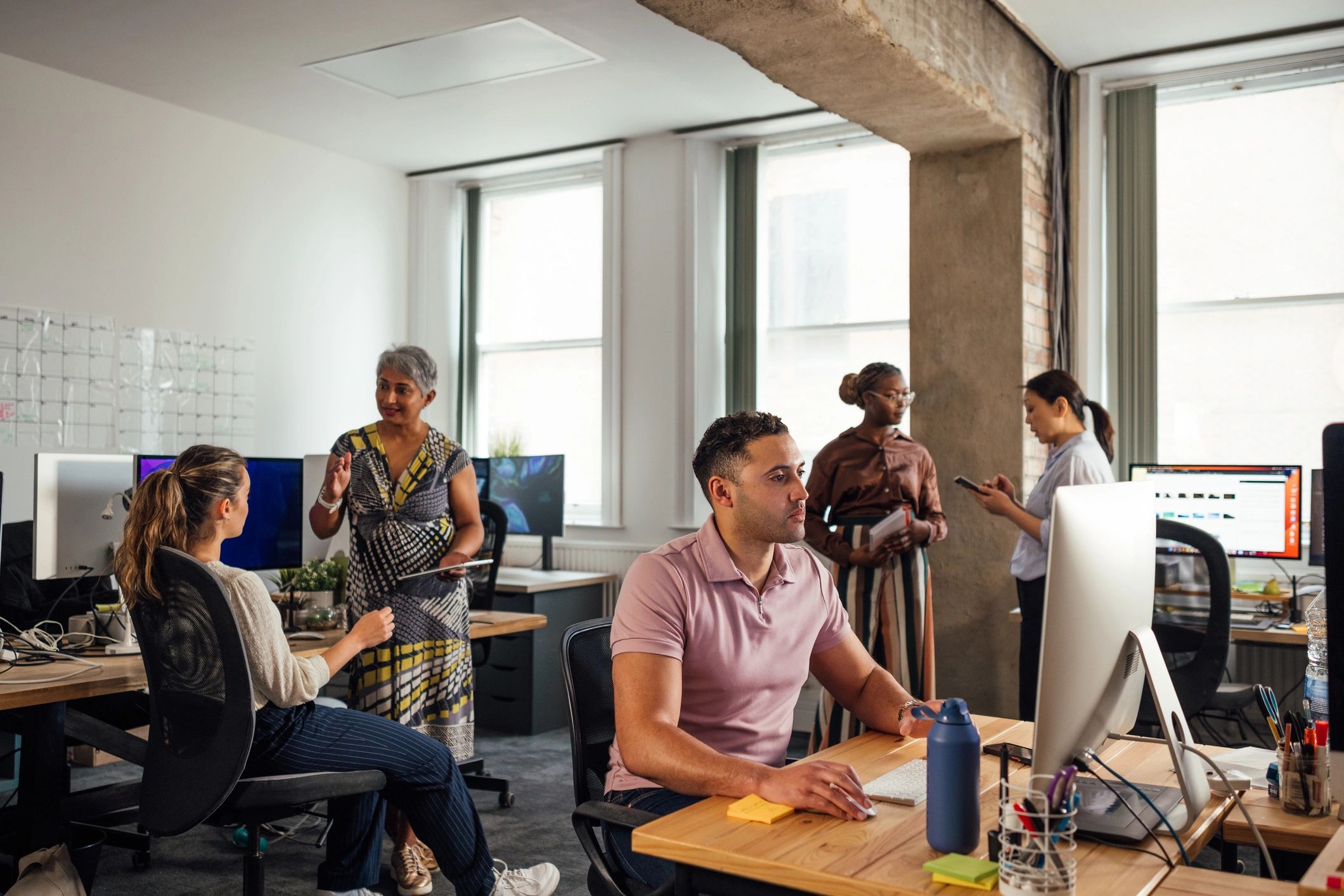 Writers and analysts collaborating in a technology-focused office